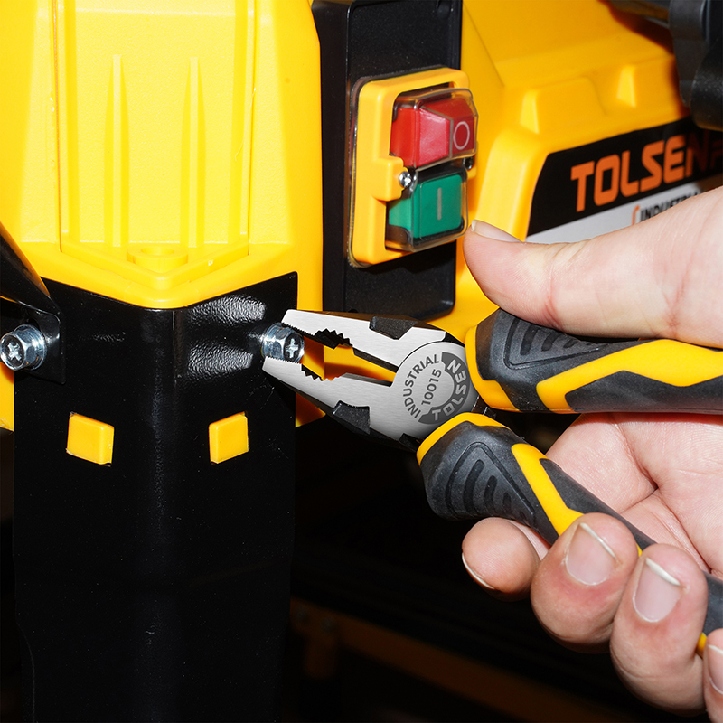 Close-up of Tolsen 6-inch combination pliers gripping a bolt on a machine