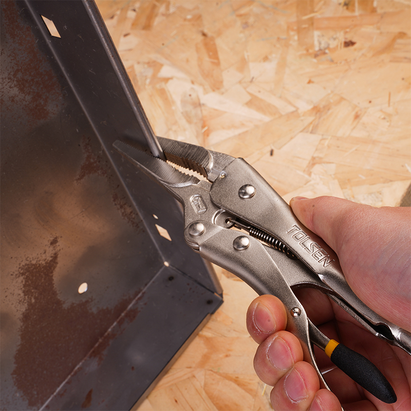 Close-up of hand holding Tolsen 9 inch locking pliers gripping metal sheet