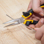 Close-up of hand using Tolsen 160mm long nose pliers to cut thin metal wire