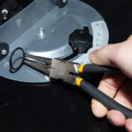 Close-up of hand using Tolsen 7 inch internal straight circlip pliers to hold circlip