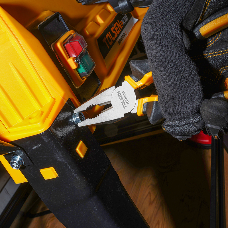 A close-up of a person using Tolsen 160mm pliers to tighten a bolt