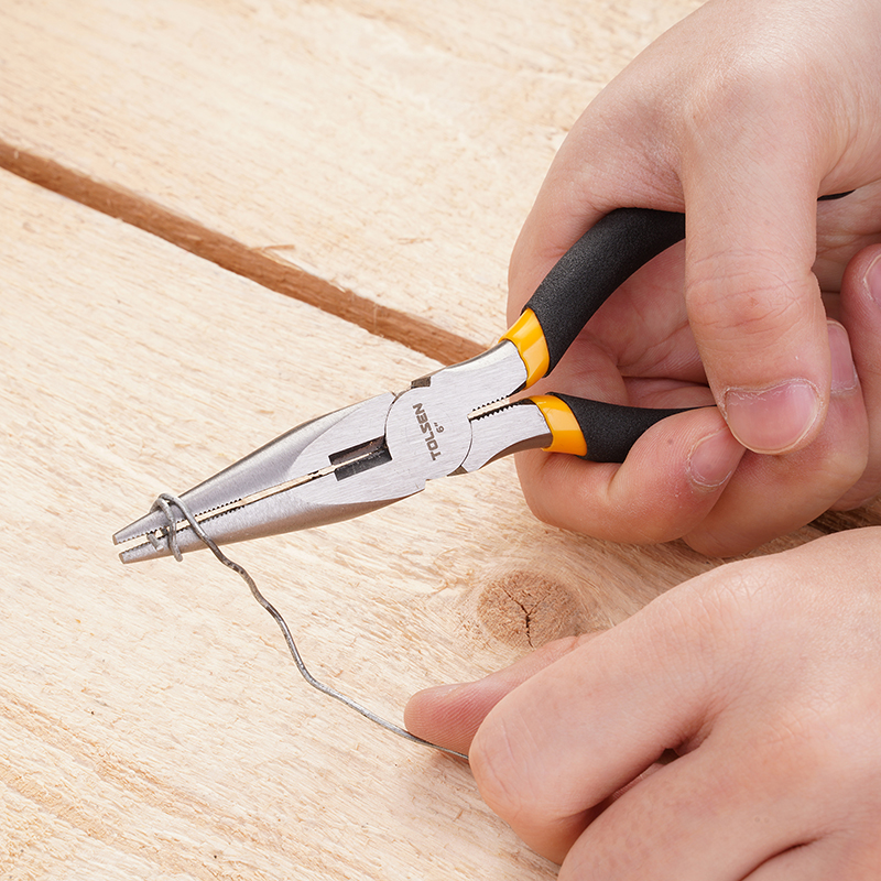 Close-up of Tolsen 6 inch long nose pliers gripping thin wire on wooden surface